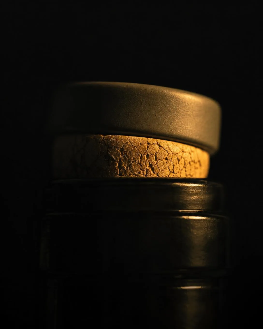 A cork standing proud of the bottle lip, pushed above the glass.